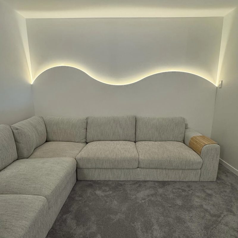 Custom curved LED feature-wall lighting in a lounge room