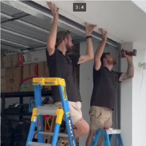 Harry and John installing motion-activated LED strip lighting in a garage